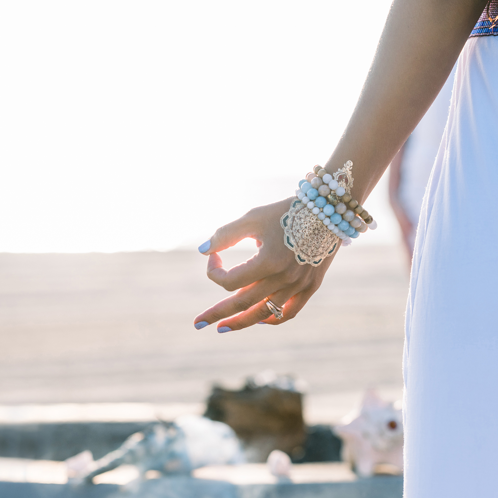 Hands with beaded bracelet and pointer and thumb touching